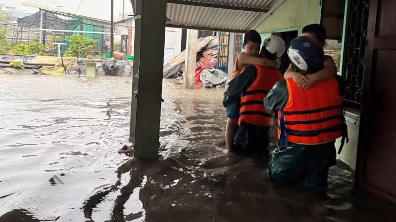 Lực lượng dân quân đưa trẻ em ở các khu vực bị ngập đến nơi an toàn.