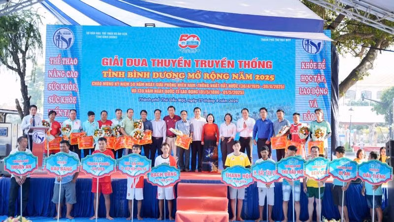 Ban tổ chức và các đại biểu trao tặng cờ cho các đội tham dự giải đua thuyền. 