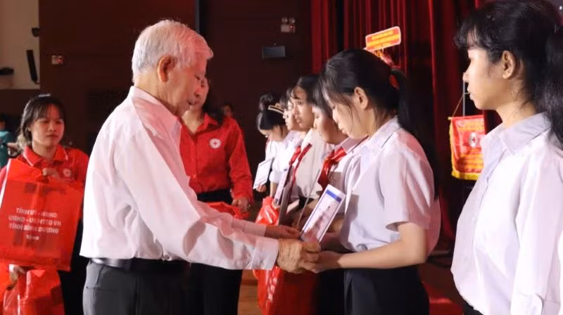 Nguyên Chủ tịch nước Nguyễn Minh Triết trao học bổng cho học sinh có hoàn cảnh khó khăn. 