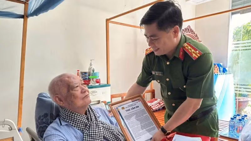 Đại tá Ngô Xuân Phú, Phó Giám đốc Công an tỉnh Bình Dương trao thư cám ơn đến thân nhân liệt sĩ phối hợp trong hoạt động thu, nhận mẫu ADN.