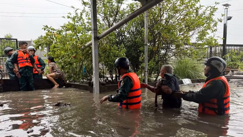 Lực lượng dân quân hỗ trợ người dân di dời khỏi khu vực bị ngập đến nơi an toàn.
