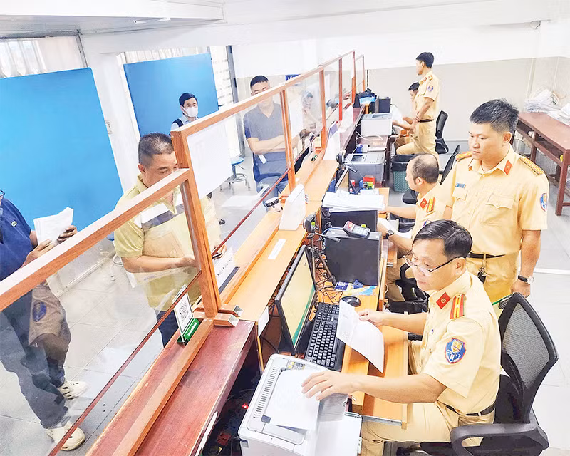 Cán bộ Cảnh sát giao thông hướng dẫn người dân, doanh nghiệp thực hiện thủ tục cấp đổi giấy phép lái xe.