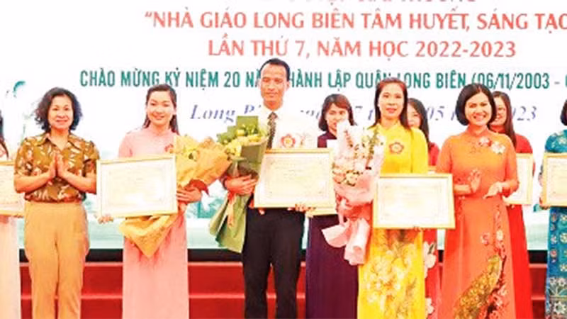 Thầy giáo Đặng Vũ Hiệp (người đứng giữa) nhận giải thưởng “Nhà giáo Long Biên tâm huyết, sáng tạo lần thứ 7, năm học 2022-2023”.