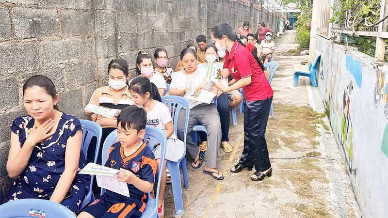 Cán bộ Hội Nông dân phường Linh Trung, thành phố Thủ Đức phát tờ rơi tuyên truyền về Luật Cư trú cho công dân trên địa bàn.