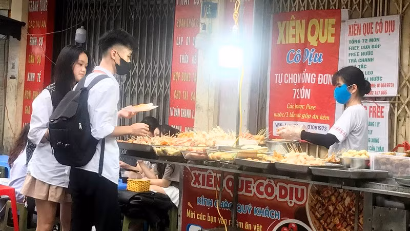 Một quầy bán thức ăn chế biến sẵn trên vỉa hè tại quận Hà Ðông (thành phố Hà Nội).