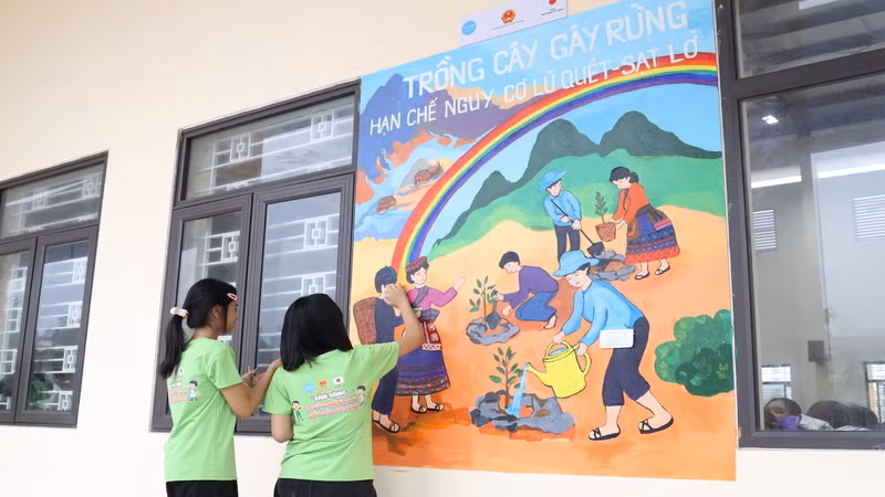 Các em học sinh Trường phổ thông dân tộc nội trú Trung học cơ sở và Trung học phổ thông huyện Bảo Thắng, tỉnh Lào Cai vẽ tranh tường.