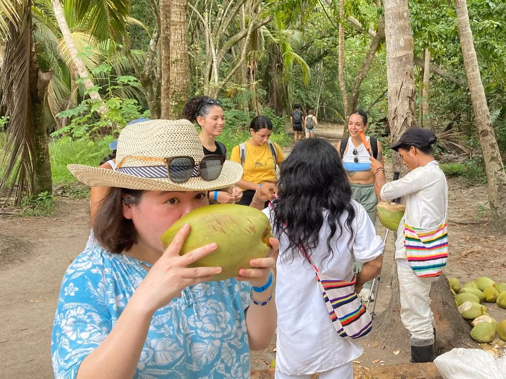 Uống nước dừa của người dân tộc Kogi (áo trắng) trong Vườn quốc gia Tayrona.