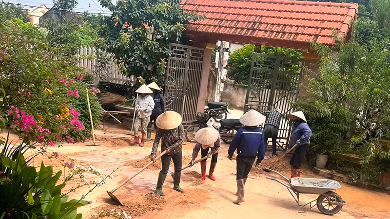 Người dân thôn Tân Sơn dọn dẹp bùn đất sau trận mưa lớn.