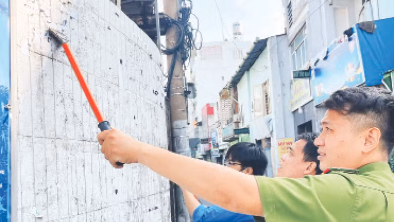 Lực lượng chức năng Quận 3 phối hợp ra quân bóc xóa quảng cáo sai quy định trên địa bàn.