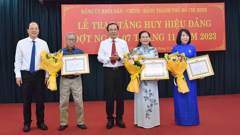 Đồng chí Nguyễn Văn Nên, Ủy viên Bộ Chính trị, Bí thư Thành ủy Thành phố Hồ Chí Minh và đồng chí Nguyễn Hồ Hải, Phó Bí thư Thành ủy chúc mừng đảng viên được nhận Huy hiệu Đảng.