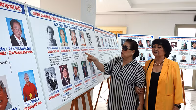 Các nghệ sĩ tham quan triển lãm ảnh.