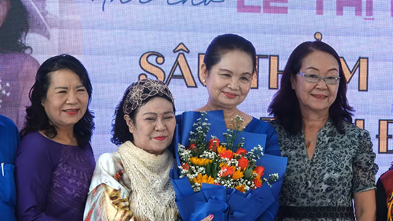 Nhà thơ Lê Thị Kim (thứ hai từ trái sang) nhận hoa chúc mừng của Hội Nhà văn Thành phố Hồ Chí Minh.