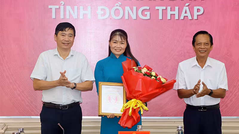 Chủ tịch Ủy ban nhân dân tỉnh Đồng Tháp trao quyết định chúc mừng bà Phạm Thị Ngọc Đào. (Ảnh: VIỆT TIẾN)