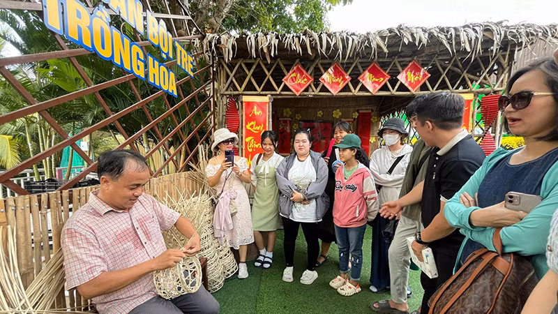 Nông dân làng hoa biểu diễn nghề đan bội tre trồng hoa.