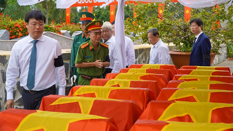 Đoàn đại biểu viếng hài cốt liệt sĩ. (Ảnh: HỮU NGHĨA)