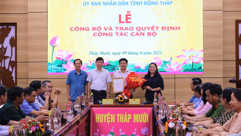 Ông Phạm Thiện Nghĩa trao quyết định, Bí thư Huyện ủy Tháp Mười Trần Thị Quý tặng hoa chúc mừng ông Đoàn Thanh Bình. (Ảnh: THÀNH NHƠN)