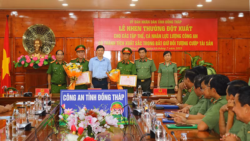 Chủ tịch Ủy ban nhân dân tỉnh Đồng Tháp Phạm Thiện Nghĩa cùng Ban Giám đốc Công an tỉnh Đồng Tháp trao bằng khen và hoa chúc mừng các tập thể có thành tích xuất sắc. (Ảnh: PHƯỚC THANH)