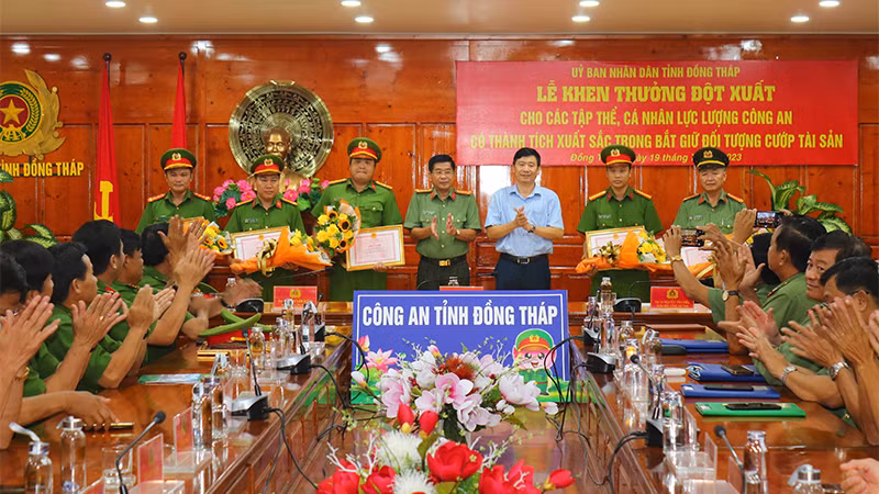 Chủ tịch Ủy ban nhân dân tỉnh Đồng Tháp Phạm Thiện Nghĩa cùng Đại tá Nguyễn Văn Hiểu, Giám đốc Công an tỉnh Đồng Tháp trao bằng khen và hoa chúc mừng cho các cá nhân có thành tích xuất sắc. (Ảnh: PHƯỚC THANH)