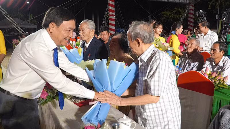 Phó Bí thư Thường trực Tỉnh ủy Đồng Tháp Phan Văn Thắng tặng hoa nhân chứng lịch sử. (Ảnh: HỮU NGHĨA)