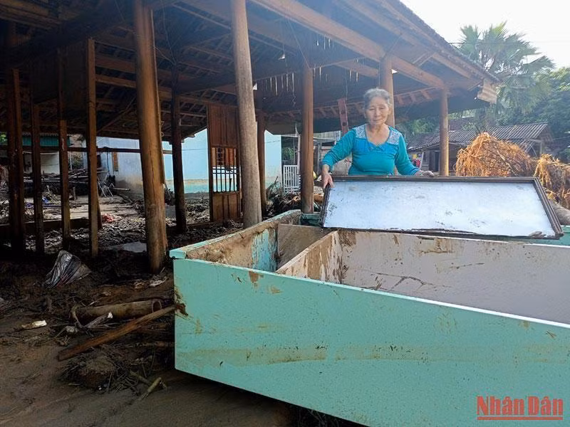 Bà Ngân Thị Tâm (71 tuổi), bản Hòa Sơn, xã Tà Cạ, nhà bị lũ trôi hết, chỉ kịp chạy thoát thân, đang lần tìm tài sản trong bùn cát. Hai nhà con bên cạnh cũng rơi vào hoàn cảnh tương tự.