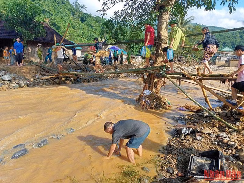 Nước suối Huồi Giảng dâng cao, bộ đội và dân quân làm cầu tạm qua để ứng cứu cho các hộ dân bản Hòa Sơn bên kia suối.
