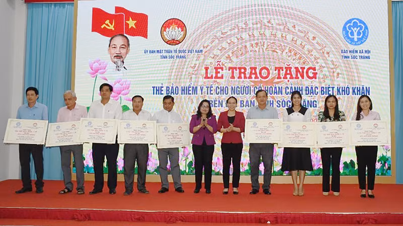 Lãnh đạo tỉnh Sóc Trăng trao bảng tượng trưng tặng thẻ bảo hiểm y tế cho người có hoàn cảnh đặc biệt khó khăn. 