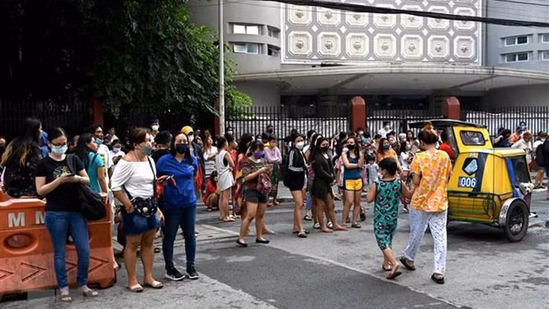 Người dân tại Manila, Philippines, sơ tán ra bên ngoài các tòa nhà sau trận động đất ngày 27/7/2022. (Ảnh minh họa: AFP/ TTXVN)