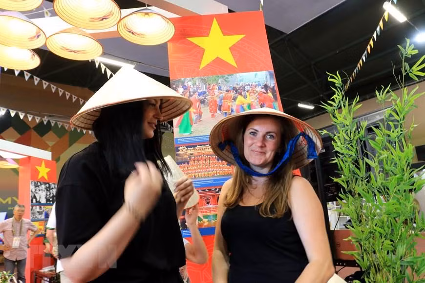 Những cô gái Nga luôn bị cuốn hút bởi vẻ đẹp độc đáo của chiếc nón lá Việt Nam. (Ảnh: Trần Hiếu/TTXVN)