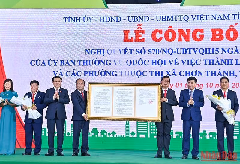 Chủ tịch Quốc hội Vương Đình Huệ trao Nghị quyết của Ủy ban Thường vụ Quốc hội cho lãnh đạo thị xã Chơn Thành. (Ảnh: Duy Linh)