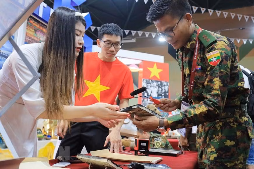 Sĩ quan trẻ của Đoàn quân đội Myanmar tự tay làm tranh dân gian Đông Hồ để mang về làm quà cho người thân ở quê nhà. (Ảnh: Trần Hiếu/TTXVN)