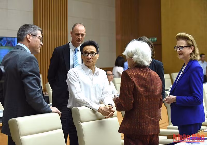 Phó Thủ tướng Vũ Đức Đam trao đổi với các đại biểu nước ngoài trong giờ nghỉ giải lao.