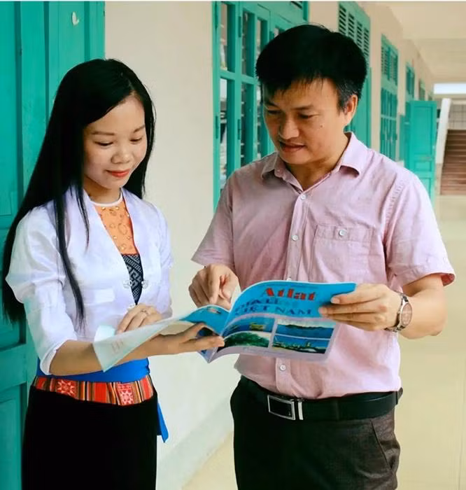 Thầy giáo Nguyễn Mạnh Hùng hướng dẫn học sinh tra cứu Atlat khi học Địa lý.