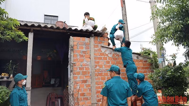 Các lực lượng chức năng giúp người dân thị xã Đức Phổ (Quảng Ngãi) chằng chống nhà cửa.