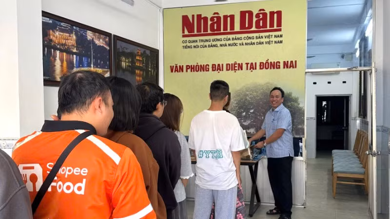 Bạn trẻ xếp hàng nhận phụ san đặc biệt ở Văn phòng đại diện Báo Nhân Dân tại Đồng Nai.