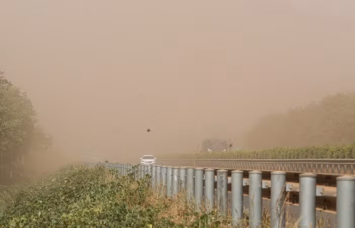 Phương tiện lưu thông trên đường cao tốc bị ảnh hưởng do bụi đỏ bao phủ.