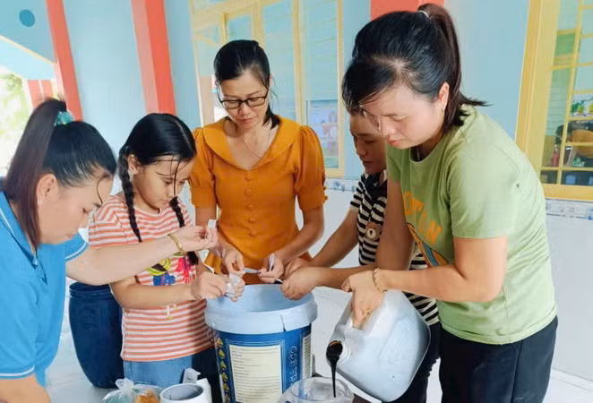 Giáo viên, nhân viên trường mầm non Thanh Bình đang chuẩn bị nguyên liệu để làm chế phẩm khử mùi hôi phòng vệ sinh.
