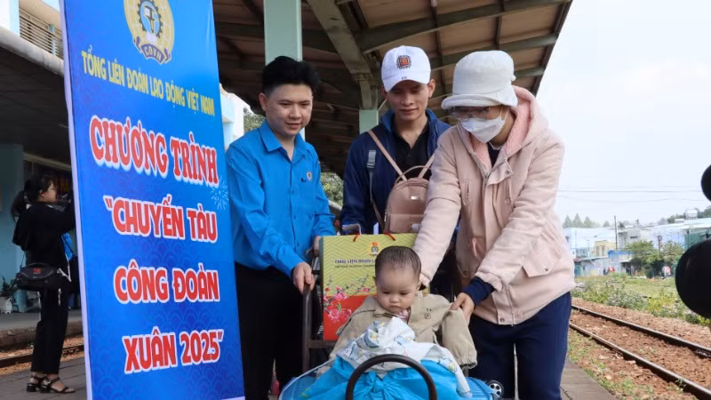 Cán bộ công đoàn hỗ trợ gia đình một công nhân di chuyển hành lý lên tàu.