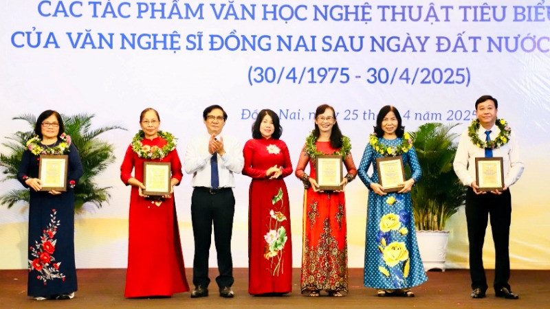 Phó Chủ tịch HĐND tỉnh Đồng Nai Hoàng Thị Bích Hằng và Phó Chủ tịch UBND tỉnh Nguyễn Sơn Hùng trao biểu trưng tôn vinh cho đại diện gia đình các văn nghệ sĩ.
