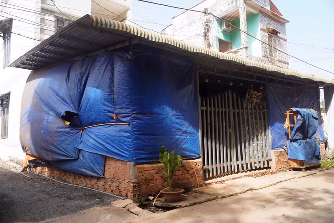 Người dân xã Bình Sơn, huyện Long Thành, tỉnh Đồng Nai buộc phải dùng bạt che nhà để chắn bụi đỏ vào bên trong.