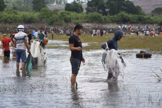 Người dân sử dụng lưới để bắt cá tại khu vực chân đập tràn phía hạ lưu.