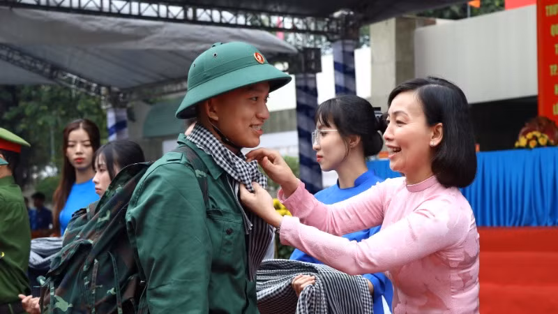 Giám đốc Sở Giáo dục và Đào tạo Đồng Nai, Thành viên Hội đồng Nghĩa vụ quân sự tỉnh đeo khăn rằn cho thanh niên trước lúc lên đường về đơn vị tại điểm giao nhận quân thành phố Biên Hòa.