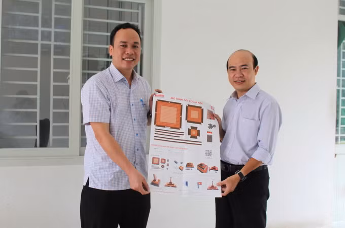 Đại diện Ban Giám hiệu Trường trung học cơ sở Nguyễn Bỉnh Khiêm tiếp nhận phụ san Báo Nhân Dân về Cột cờ Hà Nội.