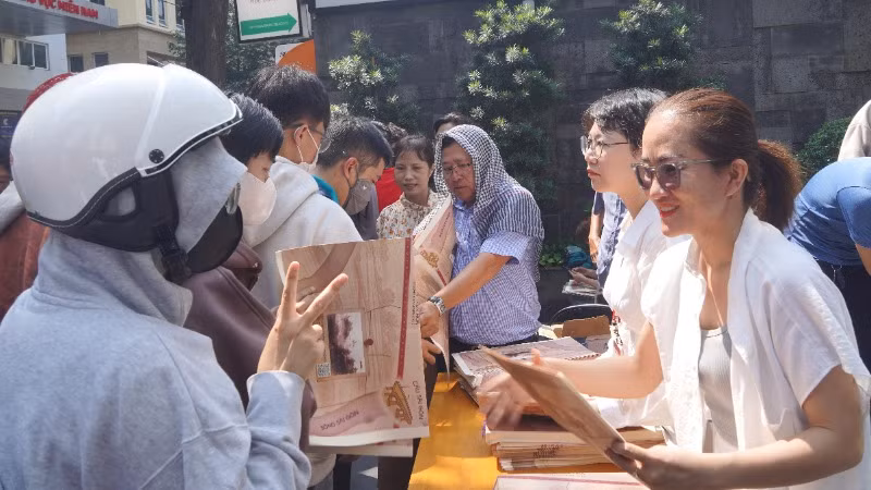 Lãnh đạo và cán bộ, công nhân viên Cơ quan đại diện Báo Nhân Dân khu vực miền nam phát phụ san đến tay bạn đọc. (Ảnh: THẾ ANH)