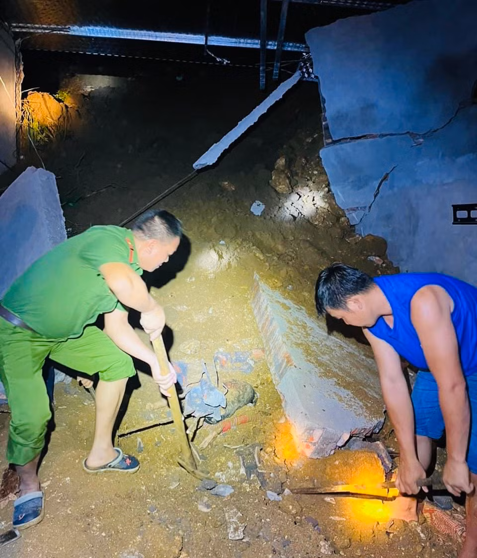 Lực lượng cứu hộ tìm kiếm nạn nhân bị tường đè do sạt đất tại xã Ngòi A, huyện Văn Yên.