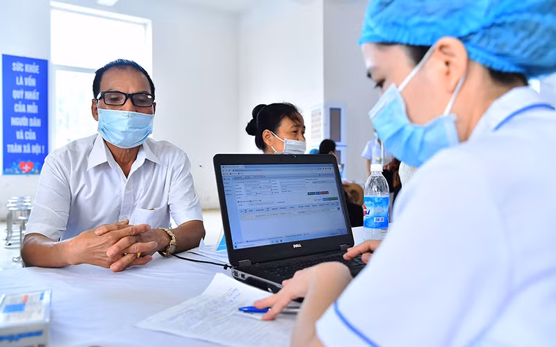 Ngành y tế Hà Nội ứng dụng công nghệ thông tin trong lập hồ sơ, quản lý sức khỏe người dân bằng phần mềm. Trong ảnh: Khám, chữa bệnh cho người dân huyện Mê Linh, thành phố Hà Nội. (Ảnh MỸ HÀ)