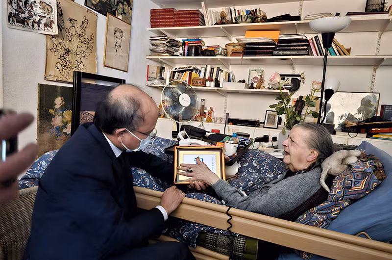 Đại sứ Đinh Toàn Thắng tặng bức tranh tem kỷ niệm 50 năm thiết lập quan hệ ngoại giao Việt Nam-Pháp cho bà Madeleine Riffaud. (Ảnh: Minh Duy)