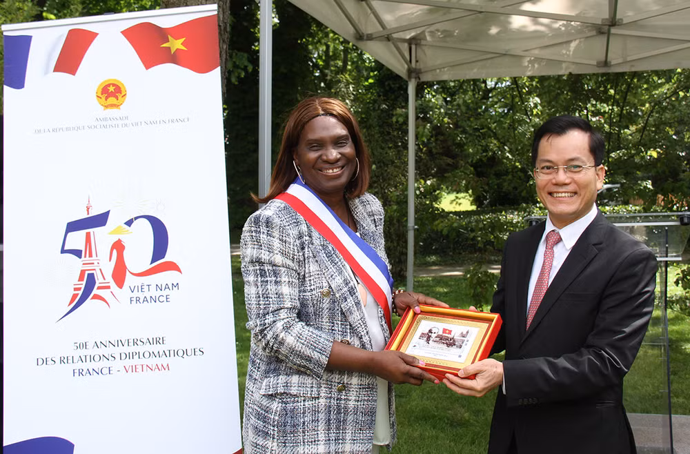 Thứ trưởng Ngoại giao Hà Kim Ngọc tặng tranh tem kỷ niệm 100 năm Bác Hồ đặt chân đến Pháp do Bưu điện Pháp phát hành cho Phó Thị trưởng Djénéba Keita. (ẢNH: KHẢI HOÀN)