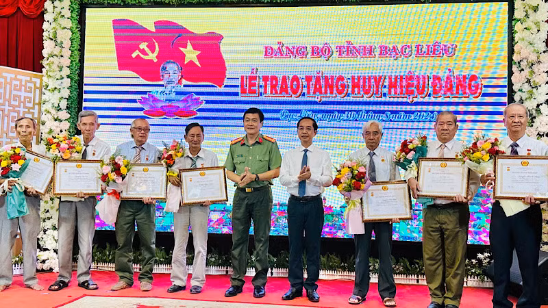 Thay mặt Ban Thường vụ Tỉnh ủy, đồng chí Hồ Thanh Thủy, Trưởng ban Tổ chức Tỉnh ủy và Đại tá Hồ Việt Triều, Giám đốc Công an tỉnh Bạc Liêu, trao Huy hiệu các đảng viên cao niên tuổi đảng.