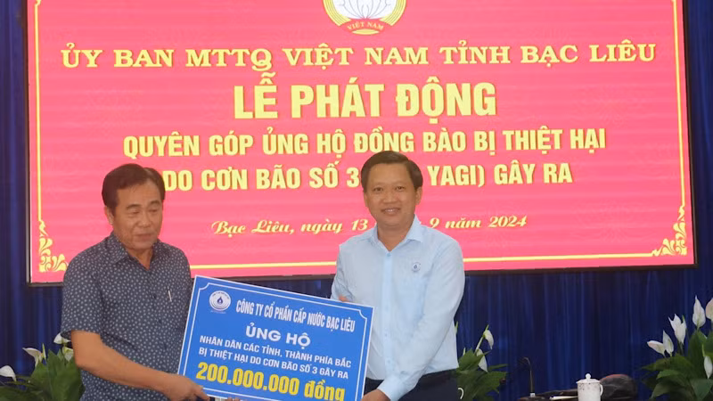 Giám đốc Công ty cổ phần Cấp nước Bạc Liêu Võ Minh Trang (bên trái) trao số tiền ủng hộ 200 triệu đồng