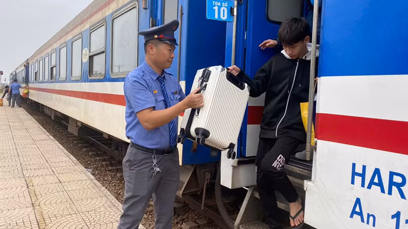 Nhân viên đường sắt hỗ trợ khách xuống tàu.